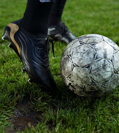 Close up of football shoes kicking to a football