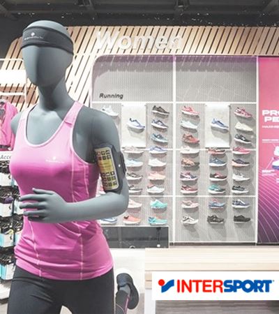 Inside Intersport store with mannequin in fornt and shoe shelfes and with Intersport logo 