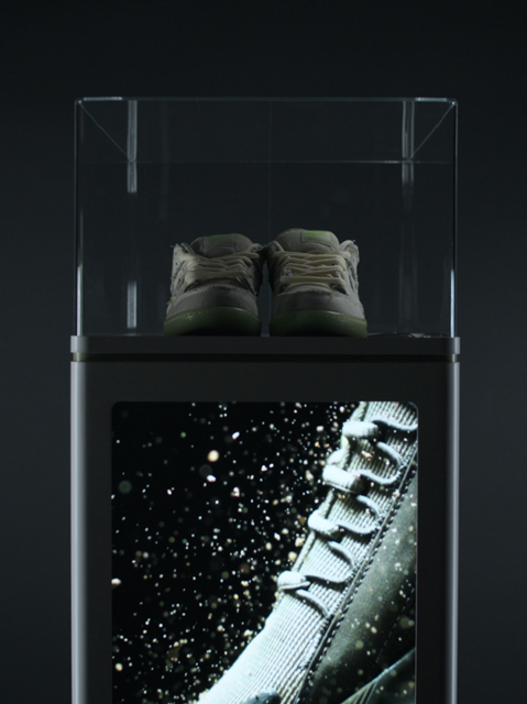 Front view of IMBOX Flagship with display video running and sneakers on top