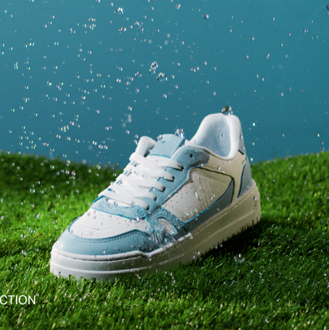 IMBOXed white and blue sneaker resisting water standing on a lane