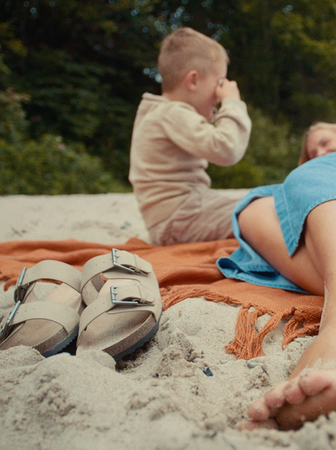 Child and mother laying in the stand having fun