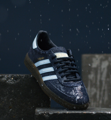 Blue and white Adidas Gazelle sneaker standing on stones repelling water