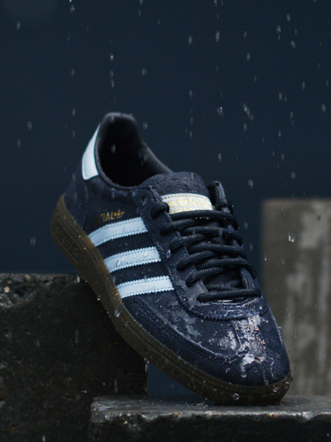 IMBOXed blue and white Addidas Spezial standing in the rain on top of stones