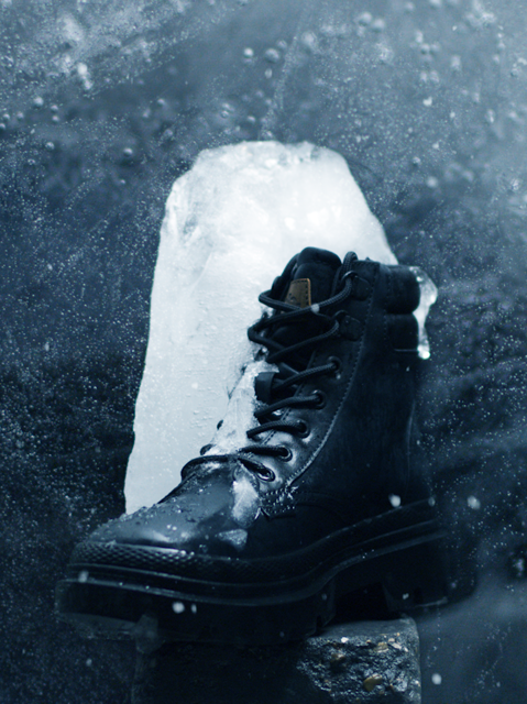 A chunk ofice frozen to a black winter boot
