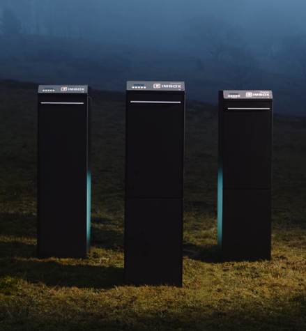 Three black IMBOX Originals standing next to each other outside on the grass with spotlight on