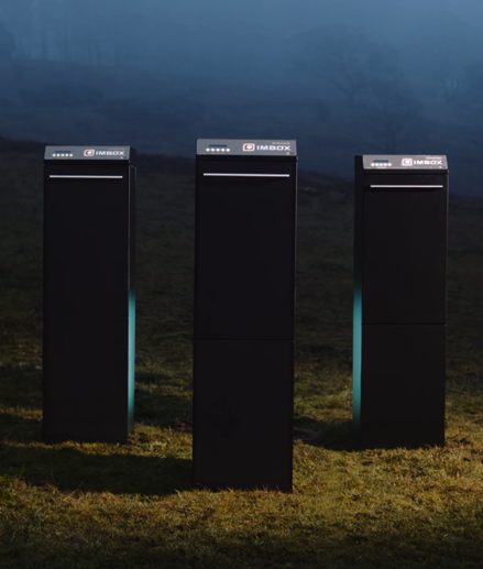 Three black IMBOX Originals standing next to each other outside on the grass with spotlight on