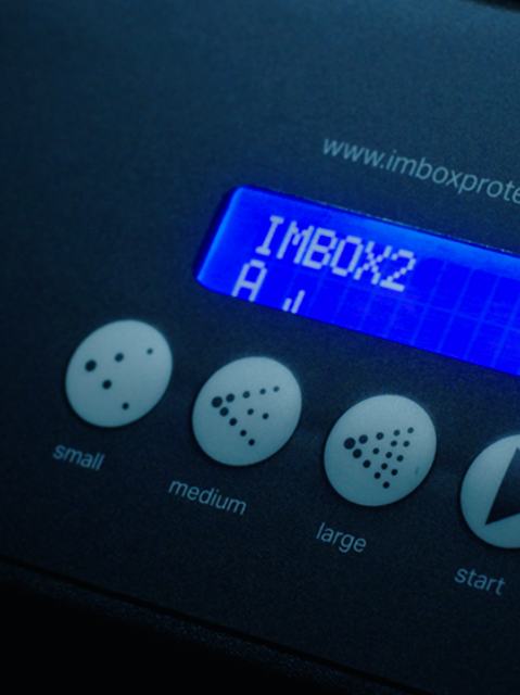 Nahaufnahme des Displays und der Unterseite des IMBOX-Originals auf grauem Hintergrund