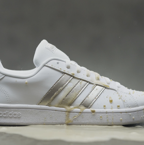  White and gold sneakers covered in liquid