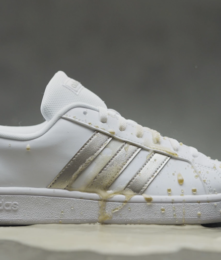 White and gold sneakers covered in liquid