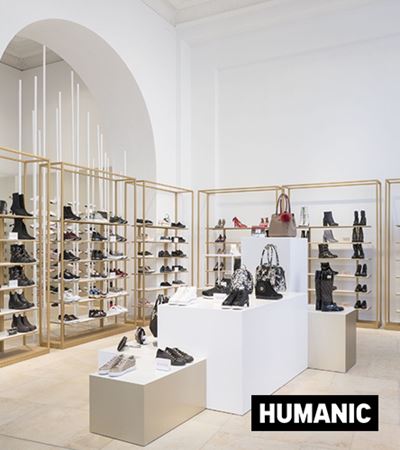 View inside of Humanic store with shoe shelves aganst the wall and shoe shelves in the center