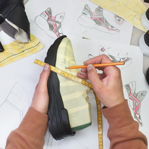 A person drawing on sneakers