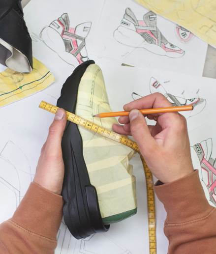 A person drawing on sneakers